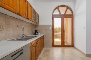 een keuken met een wastafel en een open deur bij Villa On The Beach in Pirovac