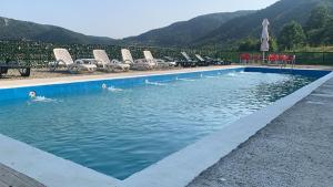 a pool with chairs and people swimming in the water at Anacor in Dubova