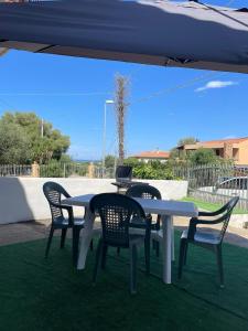 three chairs and a table with a laptop on it at Budoni -San Pietro in Tamarispa
