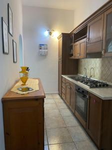 a kitchen with wooden cabinets and a counter top at Budoni -San Pietro in Tamarispa +8 photos