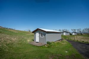 a small shed on a grassy hill next to a road at Efri-Vík Bungalows in Kirkjubæjarklaustur