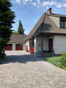 a house with red doors and a brick driveway at Ostfrieslandsuite in Aurich