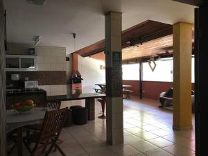 eine Küche und ein Esszimmer mit Tisch und Stühlen in der Unterkunft Chalé Vovó Zezé in Bertioga