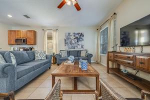 a living room with a blue couch and a table at The Hearth Home - 4 Suites in Kissimmee