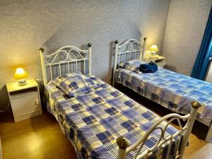 two twin beds in a room with two lamps at Gîtes de la Mouette La Moussette 5-6 personnes in Ravenoville