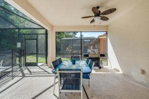 a patio with a ceiling fan and a table and chairs at The Hearth Home - 4 Suites in Kissimmee