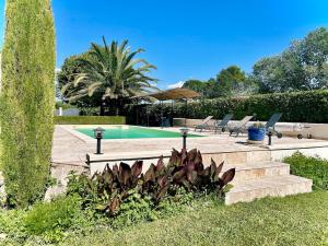 einen Pool im Garten mit Palmen in der Unterkunft Villa 7 chambres, piscine et jardins privés, pas de voisins in Le Thor