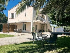 ein Tisch und Stühle vor einem Haus in der Unterkunft Villa 7 chambres, piscine et jardins privés, pas de voisins in Le Thor