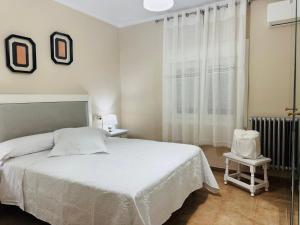 a bedroom with a white bed and a window at El Patio de Polán in Polán