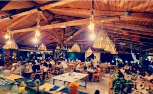 a group of people sitting at tables in a restaurant at Hotel Elisabeta Borsh in Borsh