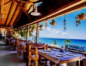 a restaurant with tables and a view of the ocean at Hotel Elisabeta Borsh in Borsh