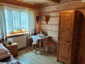a bedroom with a table and chairs in a room at Willa Płazówka in Murzasichle