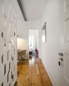 a hallway with white walls and wooden floors and a door at Flattered to be in Tomar in Tomar +121 photos