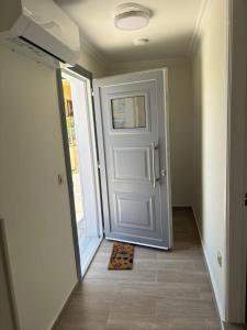 a hallway with a door and a mat on the floor at Nefeli's Hut in Mytilene