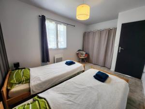 a bedroom with two beds and a window at En Ardèche, maison de vacances l'Odyssée climatisée avec sa piscine privée et chauffée in Joyeuse +19 photos