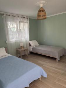 a bedroom with two beds and a window at Nefeli's Hut in Mytilene