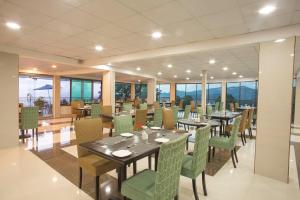 a dining room with tables and chairs and windows at Hotel Sunway Murree in Murree