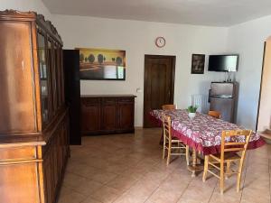 a dining room with a table and a refrigerator at La Casa Del Nonno in Ischitella