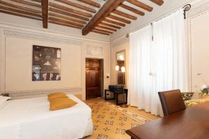 a bedroom with a bed and a desk and a table at VillAmorosa in Calci