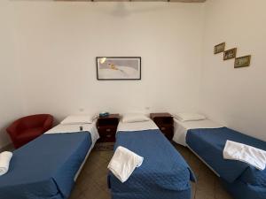 a room with three beds and a picture on the wall at Soggiorno Emanuela in Rome