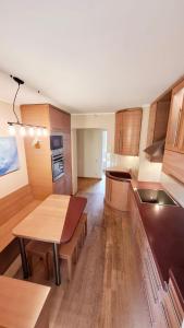 a kitchen with wooden cabinets and a table in it at Cozy Garden Villa in Ventspils