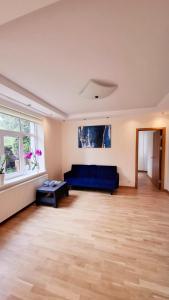 a living room with a blue couch and a table at Cozy Garden Villa in Ventspils