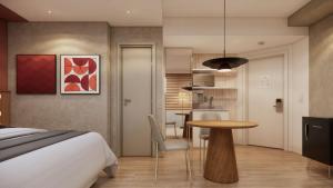 a bedroom with a bed and a table and a kitchen at TW Cyclinn Vila Olimpia in São Paulo