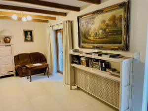 a living room with a painting on the wall at Noclegi Na Górze - Obrocz 116 in Obrocz