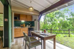 an outdoor kitchen with a wooden table and chairs at Loup Blanc in Bouillante