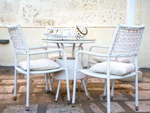 een tafel met drie stoelen en een tafel met cake erop bij B&B Corte dell' Idume in Lecce +61 foto's