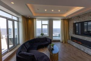a living room with a couch and a tv at Baltic Beach Hotel & SPA in Jūrmala