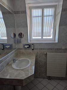 a bathroom with a sink and two windows at Hotel Porta Nigra VICTUS in Trier +22 photos