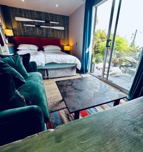 een slaapkamer met een bed, een bank en een tafel bij The View at Rosebank in Torpoint +18 foto's