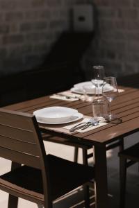 a wooden table with plates and wine glasses on it at Portonovo Suites - Riviera del Conero in Ancona +112 photos