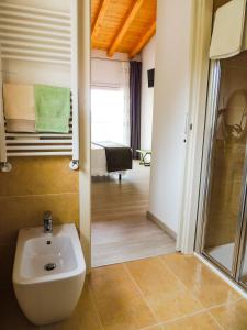 a bathroom with a toilet and a sink in a room at B&B IL RICCIO in Costermano