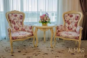 Dos sillas y una mesa con un jarrón de flores. en Almar Lake View Boutique H, en Mamaia