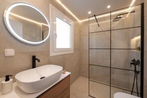 a bathroom with a sink and a mirror and a shower at Veya Suite - Private Beach & Pools in Eretria