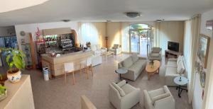a living room with white furniture and a bar at Hotel Maronti in Ischia