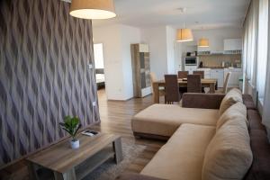 a living room with a couch and a table at Villa Sole Apartman Balatonboglár in Balatonboglár