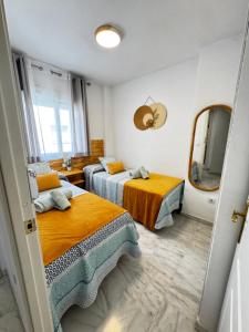 サン・ファン・デ・アスナルファラチェにあるVonitas vistas a Sevillaのベッドが2つと鏡があるホテルの部屋 +27枚の写真