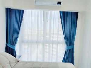 een slaapkamer met blauwe gordijnen, een bed en een raam bij ห้องใหม่ใกล้ทะเล in Jomtien Beach +10 foto's