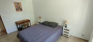 a bedroom with a large bed and a table at Bel appartement du centre ancien in Beaumes-de-Venise