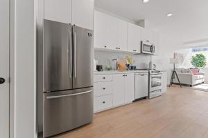 a kitchen with a stainless steel refrigerator and white cabinets at Stylish LA Getaway near Downtown - Prime Location on Wilshire Blvd! in Los Angeles