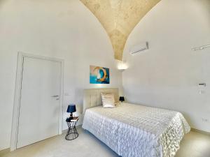 a bedroom with a bed in a white room at Pozzelle Holiday House in Zollino
