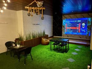 a room with a table and chairs and a projection screen at Kalarava private rooms in Chikmagalūr