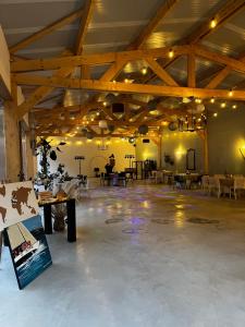 a large room with wooden ceilings and tables in it at Maison du WHITE ROCK in Saint-Jouan-des-Guérets