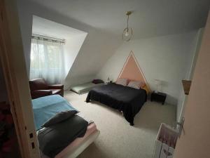 a bedroom with a bed and a couch and a chair at Maison du WHITE ROCK in Saint-Jouan-des-Guérets
