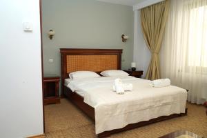 a bedroom with a large bed with towels on it at Hotel Bliss in Bucharest