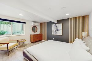 a bedroom with a bed and a chair and a window at Holly Lane Luxe in Gig Harbor