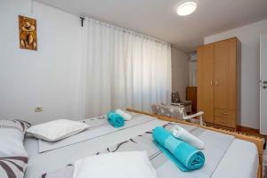 a bedroom with two beds with blue towels on them at Apartment in Novi Vinodolski 45266 in Novi Vinodolski